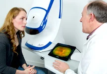 A photo of a woman talking to her doctor about optomap retinal imaging.